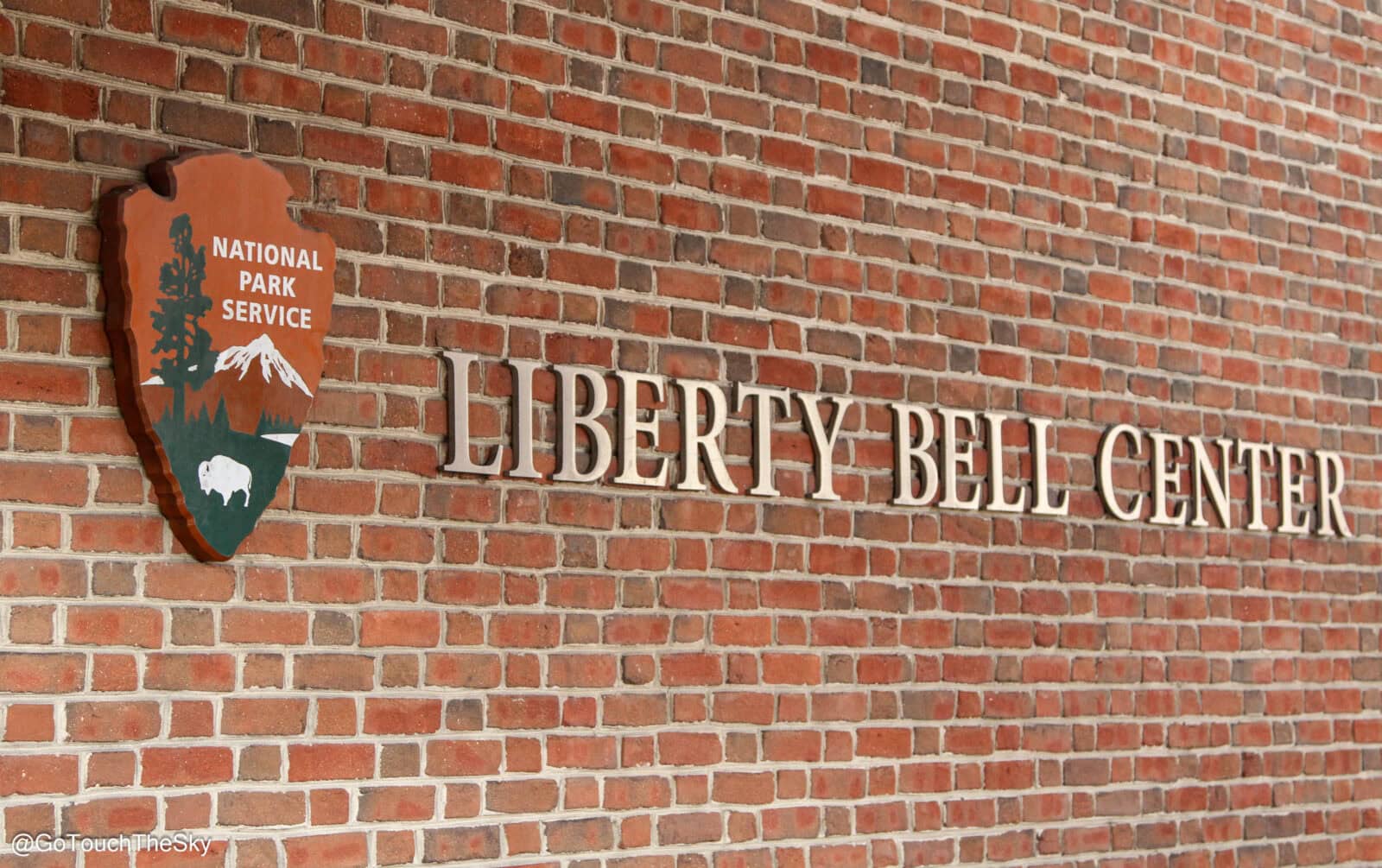 ป้าย Liberty Bell Center บนกำแพงอิฐ แสดงชื่อศูนย.