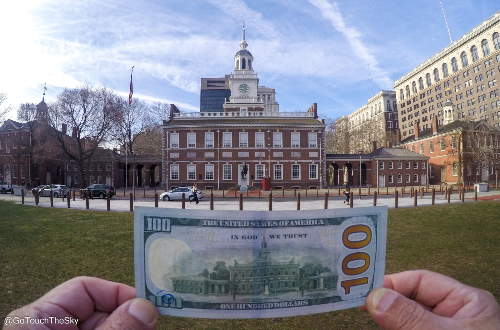 ถือธนบัตร 100 ดอลลาร์สหรัฐกับอาคาร Independence Hall เป็นฉากหลัง
